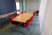 Bord med stolar i möteslokal, foto. 